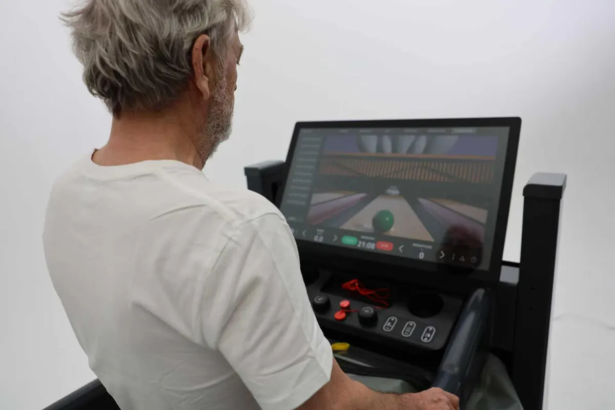 Patient playing a balance game on the touchscreen while walking